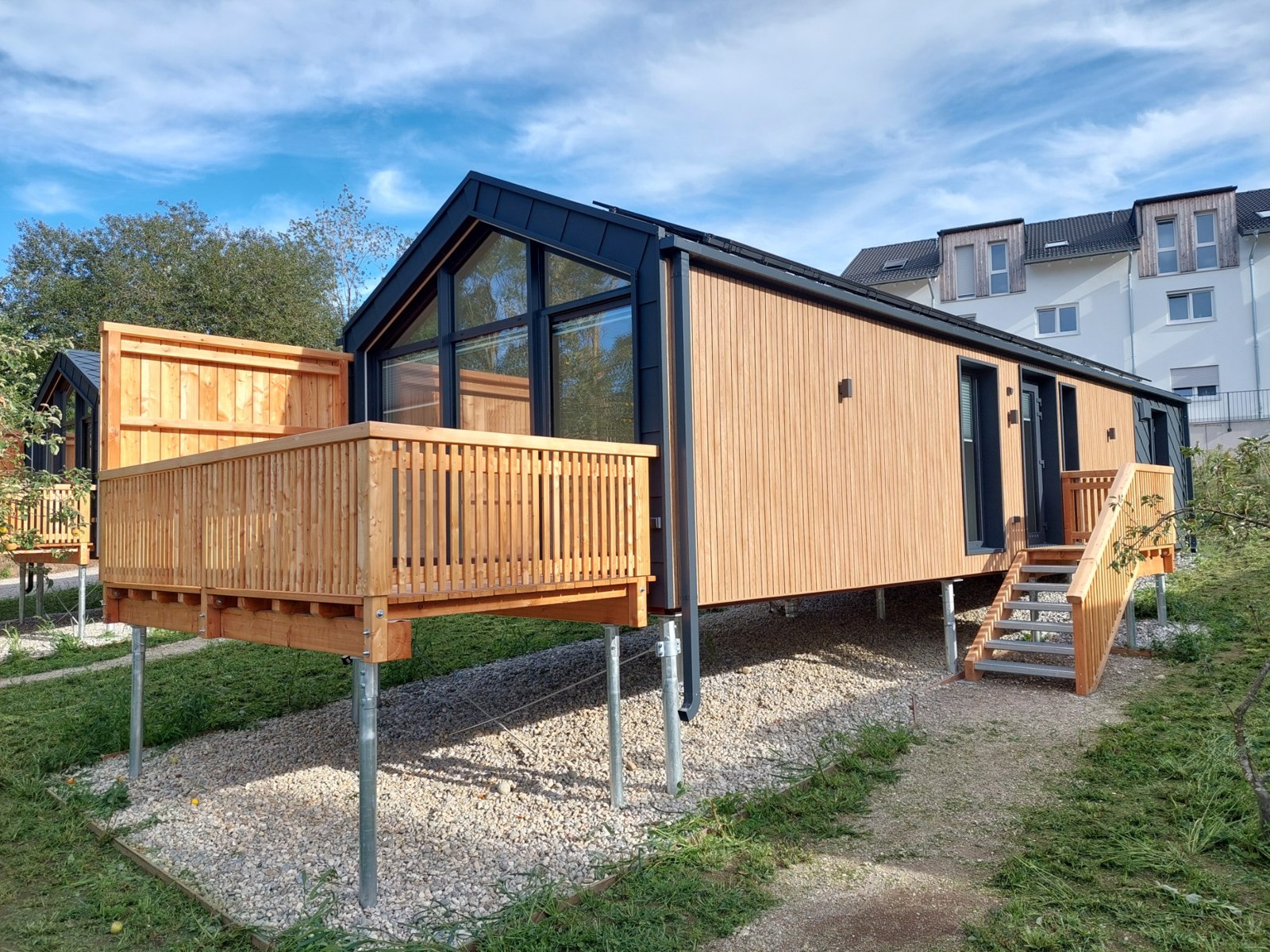 Bungalow mit großer Glasfront, Holzfassade und eigener Veranda